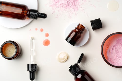 Preview: Assorted Skincare Products and Powder Spilled on a White Background