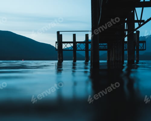 Preview: Selective focus shot from of a pathway over the water with mountains in the distance