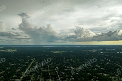 Preview: Dark stormy clouds forming on gloomy sky during heavy rainfall season over suburban town area