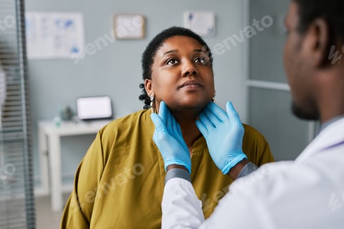 Preview: Black woman at health checkup with doctor palpating neck