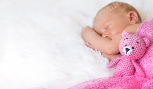 Preview: A newborn baby sleeps with a teddy bear. Selective focus.