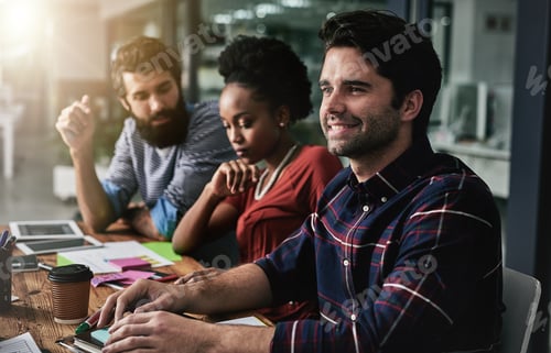 Preview: Driven by ambition. Shot of a group of designers having a discussion in an office.