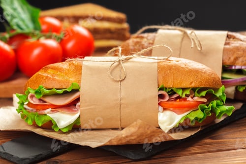 Preview: Fresh sandwiches with vegetables and meat on a wooden table
