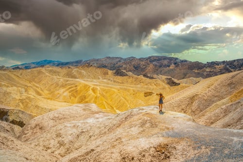 Preview: A young woman in dress enjoying the view of the viewpoint of Zabriskie Point