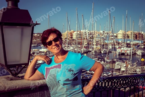 Preview: Wonderful view of the harbour. Close up of an attractive senior woman enjoying vacation