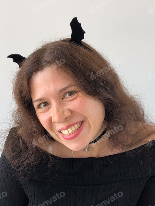 Preview: Smiling woman with Halloween bat wings on hair. Halloween, festivity and creativity concept