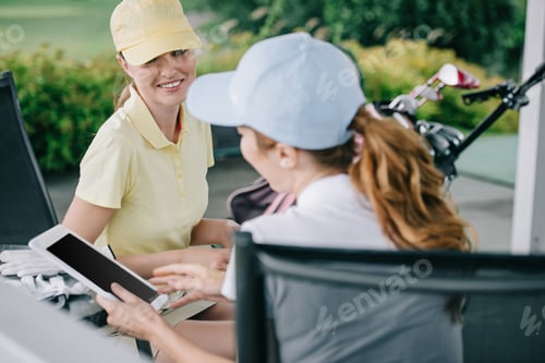 Preview: business partners with tablet discussing work after golf game at golf course