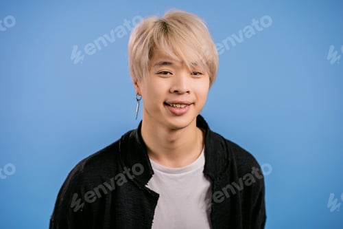 Preview: Portrait of stylish korean man looking to camera. Asian guy with dyed blonde hairstyle in studio