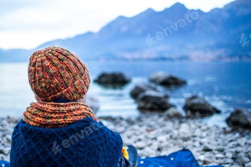 Preview: Boy sitting on blanket on lakeside, rear view, Lake Como, Onno, Lombardy, Italy