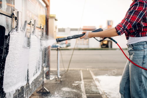 Preview: Female person with water gun cleans car mats