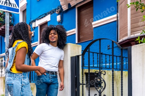 Aperçu: African couple chilling in the street chatting outside a house