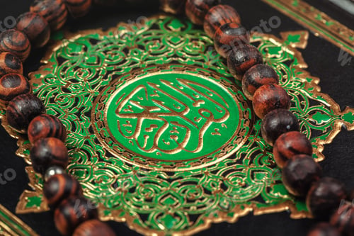 Preview: Holy Quran with beads over wooden background close up