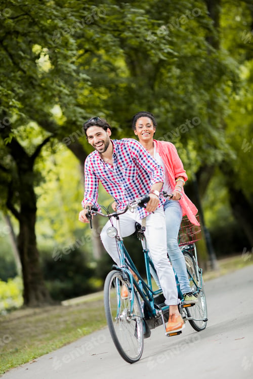 Preview: Young couple riding on the tandem bicycle