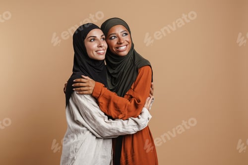 Preview: Young muslim women in hijab hugging and smiling at camera