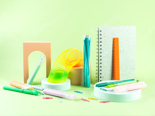 Preview: Colorful stationery copybooks set on green with geometric elements. Back to school