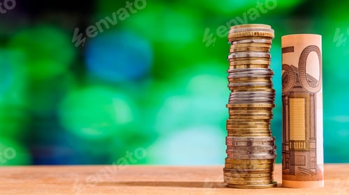Preview: Fifty euro rolled bill banknote, with euro coins on green blurred bokeh background