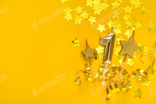Preview: Gold candle in shape of number one on yellow background surrounded by stars confetti and streamers.