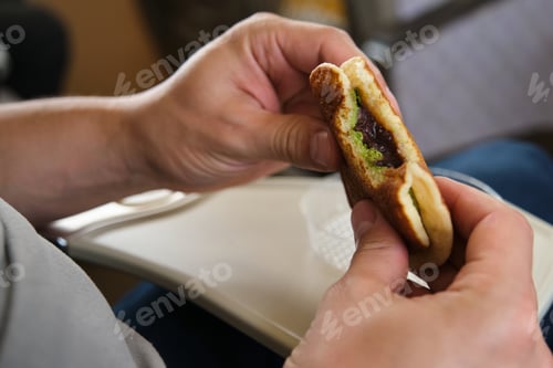 Preview: Hands holding Japanese dorayaki with matcha and red bean paste