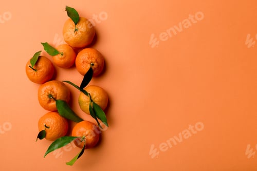 Preview: Many fresh ripe mandarin with green leaves on colored background, top view, space for text