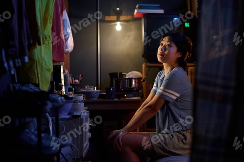 Preview: Girl sitting on bed in small apartment