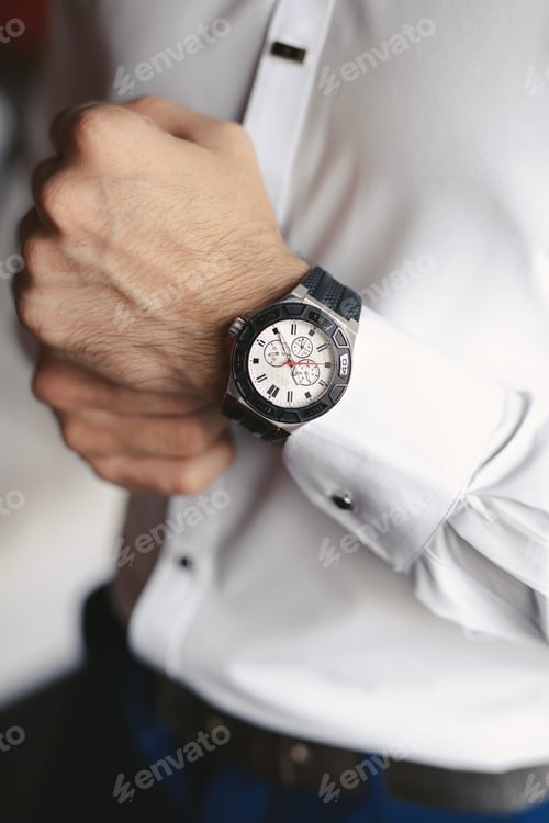 Preview: Close-up hands of the groom with a clock