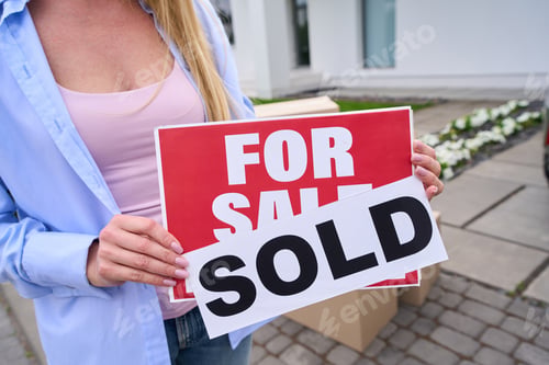 Preview: Young woman holds sign in her hands for sale, sold