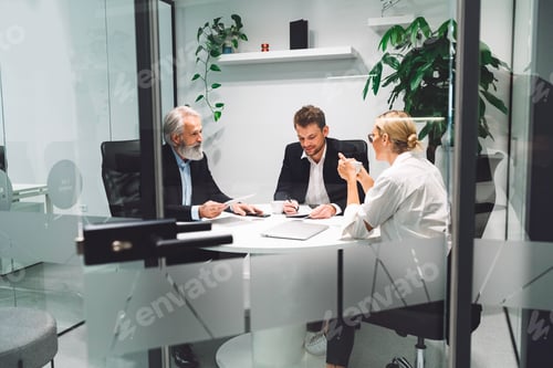 Preview: Modern glass offices where all is seen, people having a meeting in one of the offices