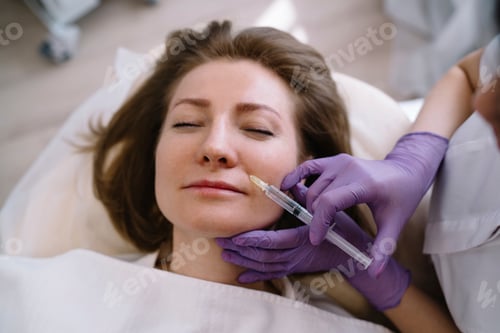 Preview: Female patient getting injection on face in professional clinic