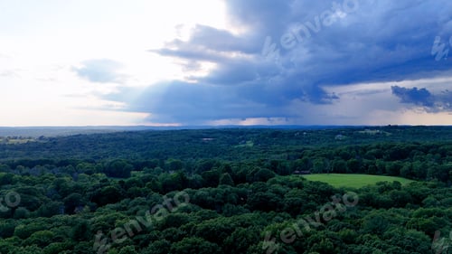 Preview: Stormy Sunset Drone photo above the green forest in rural Connecticut. Summer aerial photo of Harwin