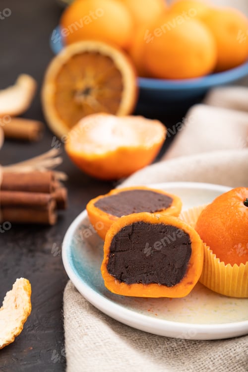 Preview: Truffle chocolate tangerine candies on a black concrete background. Side view, selective focus.