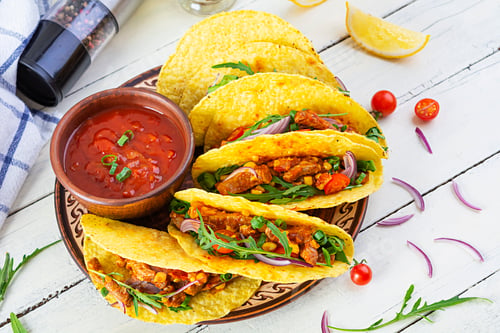 Vista previa: Mexican tacos with corn tortilla and meat on wooden background