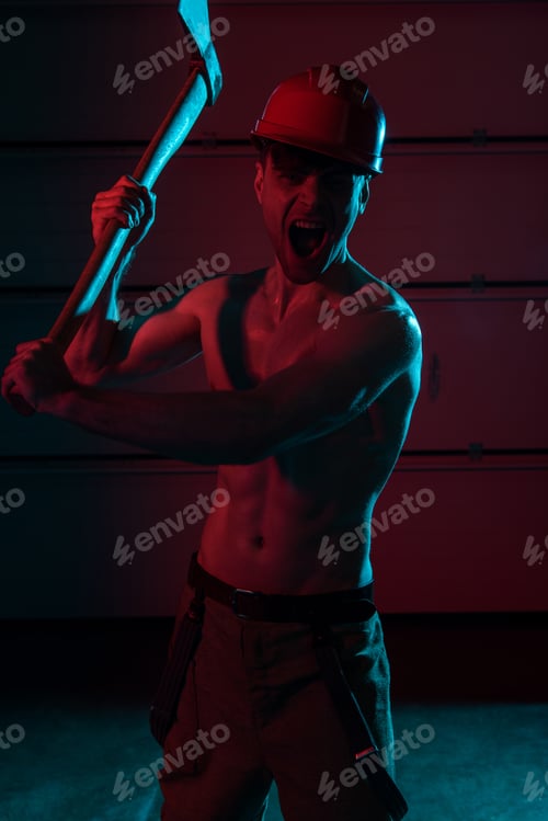 Preview: screaming sexy shirtless fireman in helmet holding flat head axe in darkness