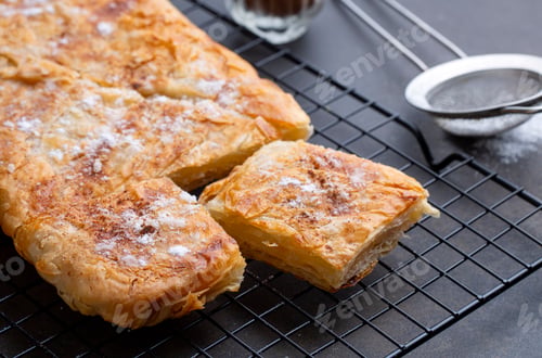 Preview: Greek pie called Bougatsa with cheese slightly blurred cross section and selective focus on powdered