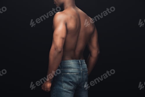Preview: back view of sexy muscular african american man in denim posing isolated on black