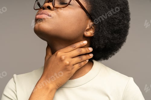Preview: Unhealthy black girl with sore throat touching painful neck suffer from angina or covid-19 disease