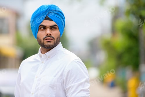 Preview: Young bearded Indian Sikh man thinking outdoors