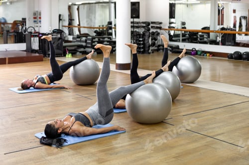 Preview: Sportswomen exercising with fit balls