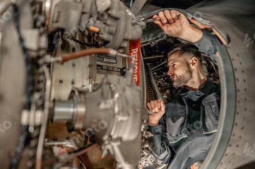 Preview: Bearded man mechanic repairing aircraft in hangar