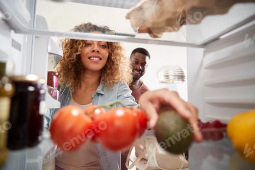 Preview: View Looking Out From Inside Of Refrigerator As Couple Open Door And Unpack Shopping Bag Of Food