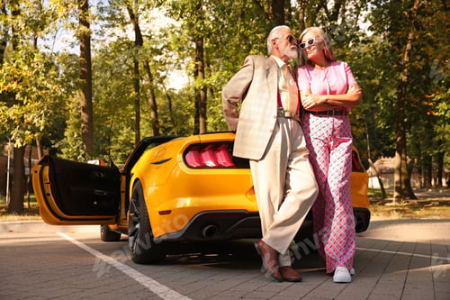 Preview: Stylish senior couple in sunglasses near modern cabriolet outdoors, low angle view