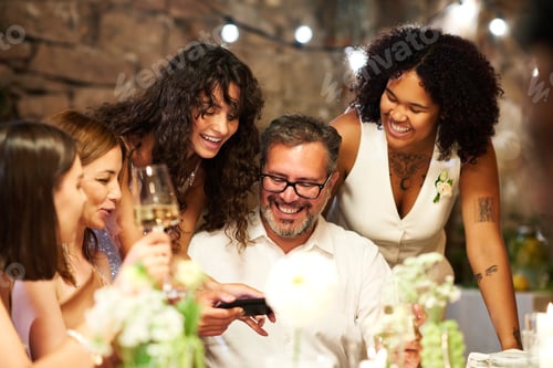 Preview: Happy young brunette bride showing her parents and friend new photos