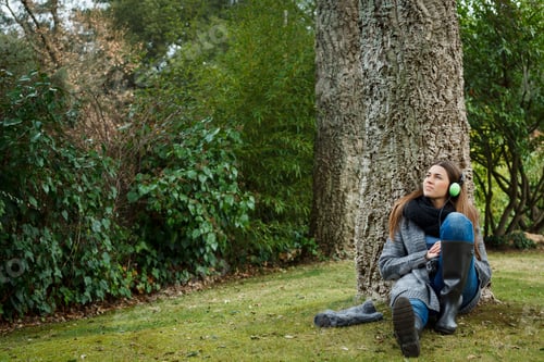 Preview: Young woman listening to music in forest