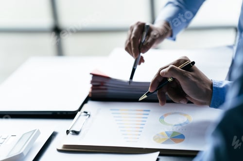 Preview: Business team reviewing a diagram or chart and financial reports