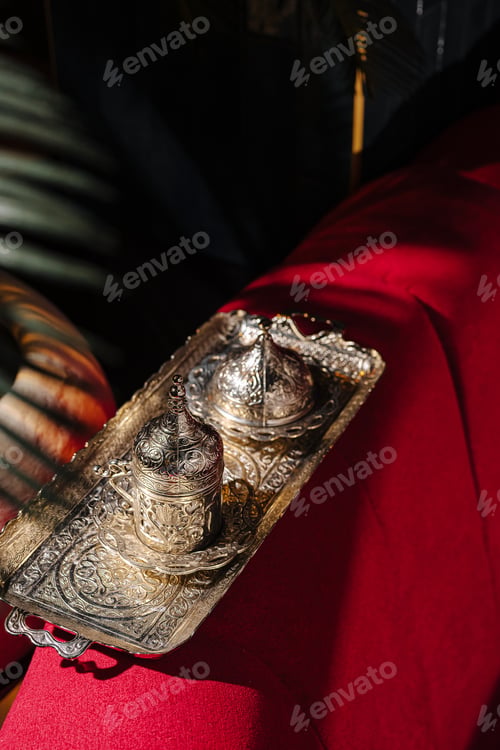 Preview: Traditional oriental metal coffee set on a red fabric background.