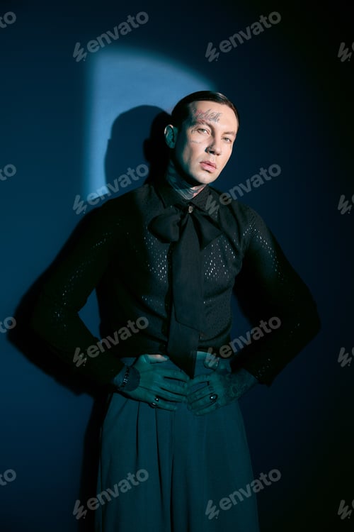 Preview: Handsome young man showcases unique fashion in stylish attire against a bold backdrop