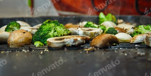 Preview: Fresh champignon mushrooms and porcini mushrooms are fried on a board along