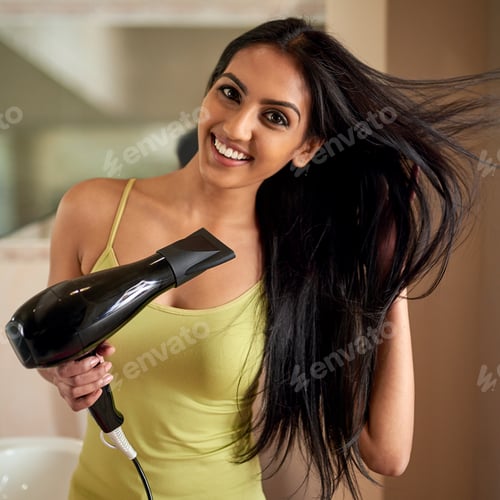 Preview: Great hair requires proper care. Portrait of a young woman blowdrying her hair in the bathroom.