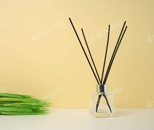 Preview: Glass flask and wooden sticks, aroma lamp on colored background