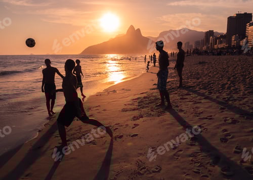 Preview: Rio de Janeiro, Brazil - February 13 2014: Young men throwing ball on beach during sunset