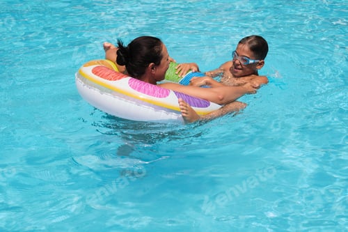 Preview: A playful wrestle with a pool ring; vacation memories made. Reflects the cultural shift towards